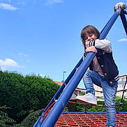Capucine a rejoint le concours — aidez-le/la à gagner de superbes lots ! active, blue_sky, casual_clothing, child, climbing, daylight, fun, greenery, happy, jeans, outdoor, park, play, playground, recreation, rope_structure, smiling, sneakers, sporty_jacket, young