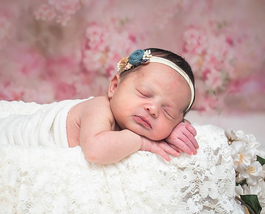 Kenzie is registered to the contest to win money with this photo: baby, baby_sleeping, baby_toddler_clothing, comfort, embellishment, fashion_accessory, flash_photography, grass, hair_accessory, happy, head, headband, headgear, headpiece, jewellery, linens, lip, person, petal, pink