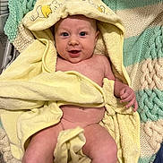 August is registered to the contest to win money with this photo: baby, towel, yellow, hood, winnie_the_pooh, knitted_blanket, green, cream, smiling, happy, infant, skin, blanket, cute, child, person, lying_down, indoors, cozy, soft