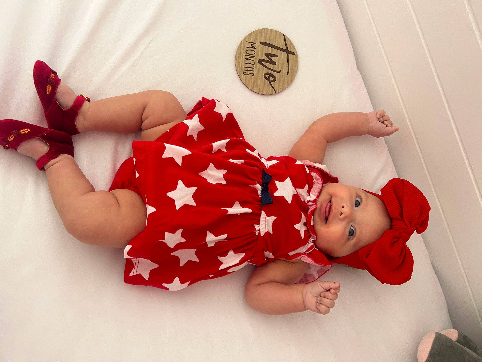Gabriella is registered to the contest to win money with this photo: arm, baby_toddler_clothing, comfort, day_dress, dress, elbow, finger, foot, hand, happy, headwear, human_body, human_leg, knee, leg, pattern, person, sleeve, smile, textile
