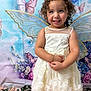 Gabriella joined the competition — help win amazing prizes! child, girl, princess, crown, wings, dress, flowers, butterflies, smile, curly_hair, bracelet, portrait, indoor, decorative_background, happy, cute, white_dress, young_child, posing, costume