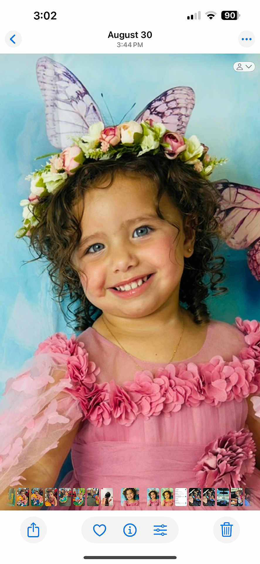 Gabriella is registered to the contest to win money with this photo: child, smiling, curly_hair, blue_eyes, pink_dress, floral_crown, fabric_flowers, butterfly_wings, portrait, face, happy, cute, fairy, costume, flower, young_girl, studio_background, skin, head, toddler