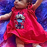 baby, infant, child, red_dress, minnie_mouse, cartoon, raising_arm, lying_down, purple_blanket, stars, pattern, cute, adorable, clothing, footwear, soft_toys, portrait, smiling, young_child, indoor