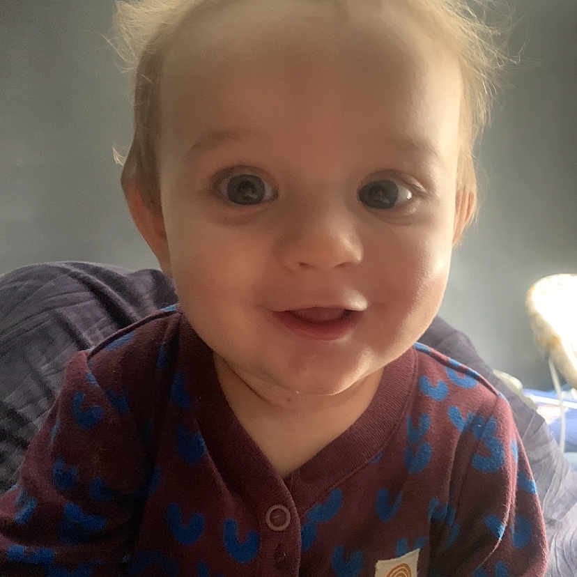 Noah is registered to the contest to win money with this photo: baby, blonde, bodypart, clothing, face, finger, hair, hand, happy, head, knitwear, longsleeve, mouth, person, photography, portrait, sleeve, smile, sweater, teeth