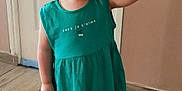 Romy a rejoint le concours — aidez-le/la à gagner de superbes lots ! toddler, child, dress, teal_dress, standing, hand_holding, indoor, wooden_floor, footwear, sandals, hair_style, curly_hair, person, smile, face, expression, door, wall, floor, cute