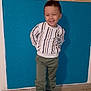 Noam participe au concours pour gagner de l'argent avec cette photo : child, boy, smiling, standing, indoor, wall, blue_wall, leaf_pattern, floor, tile_floor, clothing, sweater, pants, shoes, happy, person, portrait, casual, cute, fashion