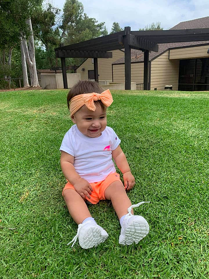 Bella joined the competition — help win amazing prizes! baby_toddler_clothing, baseball_cap, cap, grass, grassland, groundcover, happy, hat, headwear, joy, leg, leisure, meadow, people_in_nature, person, plant, shorts, sky, sneakers, sun_hat