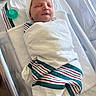 Edward is registered to the contest to win money with this photo: newborn, baby, infant, sleeping, peaceful, hospital, bassinet, swaddle, blanket, pacifier, hat, portrait, face, closed_eyes, resting, nursery, bedding, striped_fabric, indoors, photography