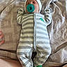 baby, infant, child, portrait, lying_down, pacifier, onesie, striped_clothing, hat, green, dinosaur_socks, couch, blanket, fabric, indoor, cozy, face, sleepy, photography, baby_clothing