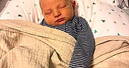 Edward is registered to the contest to win money with this photo: newborn, baby, sleeping, infant, portrait, blanket, swaddled, bed, pillow, cozy, indoors, striped_clothing, peaceful, resting, nursery, soft_lighting, close_up, face, head, home