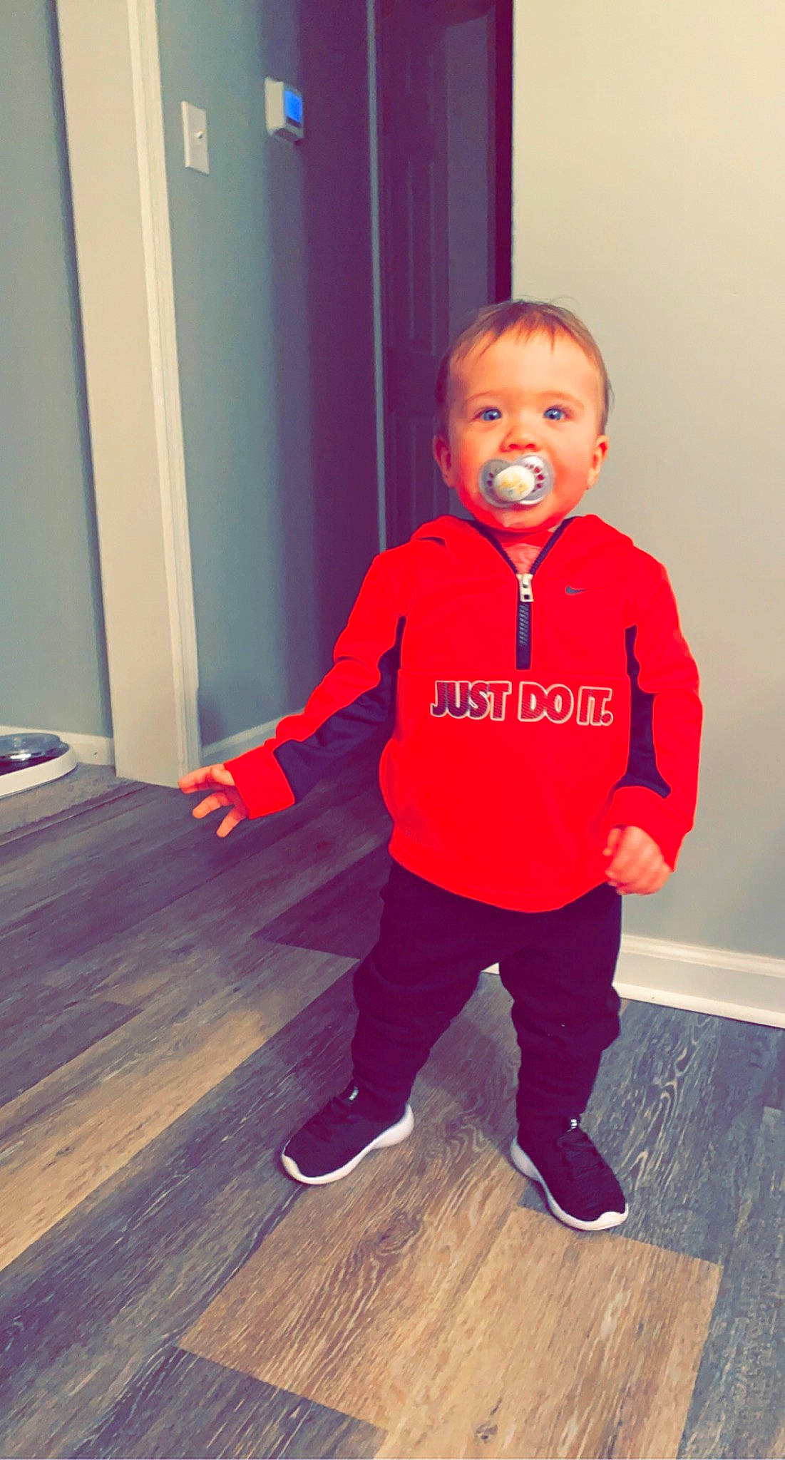 Wesley is registered to the contest to win money with this photo: baby_toddler_clothing, cheek, electric_blue, floor, flooring, happy, hardwood, human_leg, knee, laminate_flooring, leg, nose, person, shoulder, sleeve, standing, t_shirt, toddler, varnish, wood