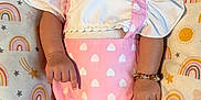Azuri Howard joined the competition — help win amazing prizes! adorable, baby, bow, bracelet, child, clothing, cute, happy, headband, heart_pattern, indoors, infant, lying_down, pattern, pillow, pink, rainbow, skin, smiling, white