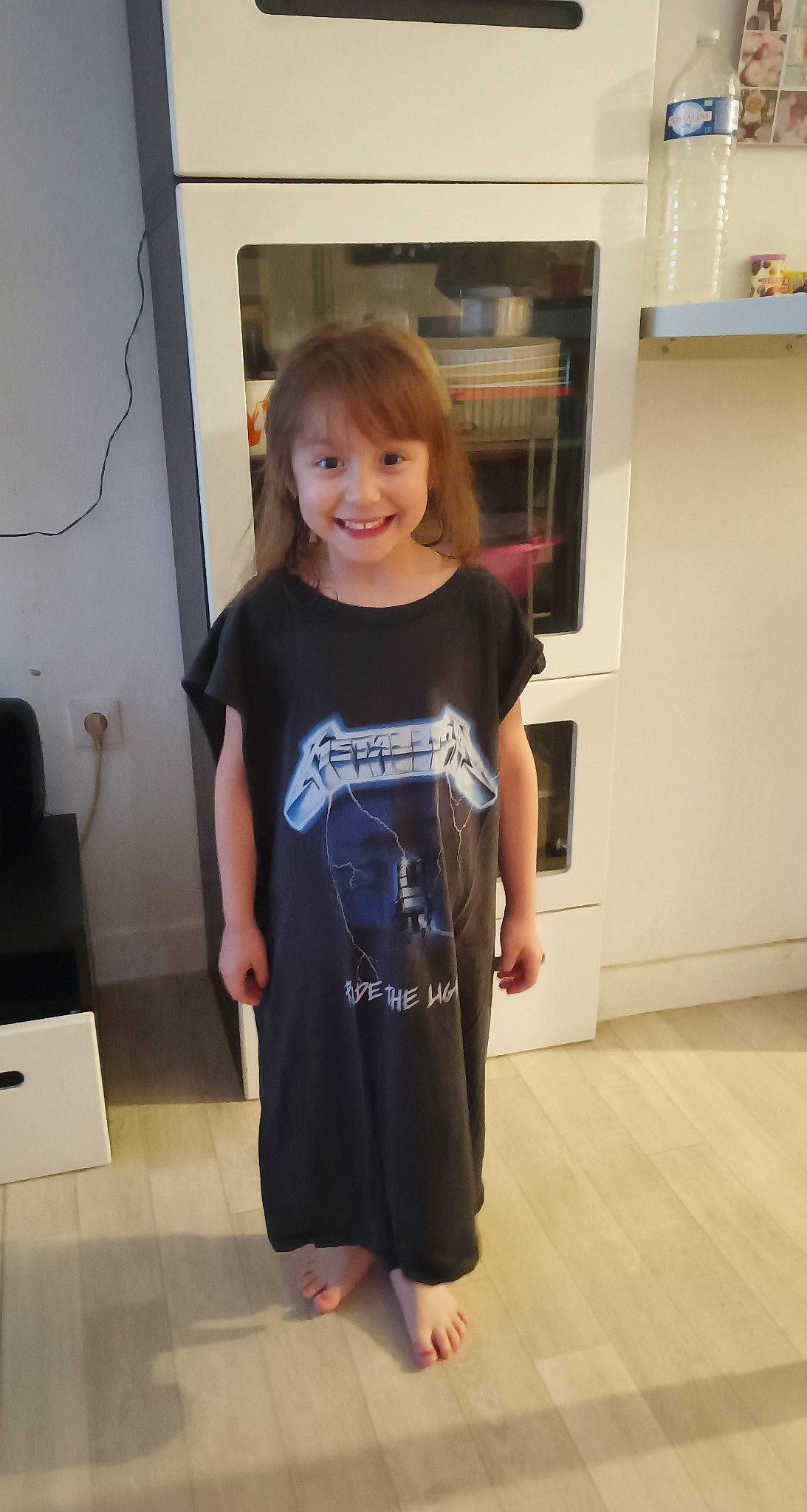 Amy participe au concours pour gagner de l'argent avec cette photo : cabinetry, electric_blue, event, face, floor, flooring, fun, hardwood, joy, kitchen_appliance, person, refrigerator, shelf, sleeve, smile, sportswear, standing, t_shirt, toddler, trunk