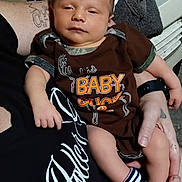 Dean joined the competition — help win amazing prizes! baby, infant, person, clothing, socks, hand, tattoo, arm, onesie, sleepy, indoor, fabric, holding, resting, casual, closeup, portrait, skin, adult, comfort