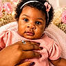 Davina is registered to the contest to win money with this photo: baby, infant, child, face, hand, headband, flower, pink, blanket, knitwear, ring, nail_polish, portrait, close_up, curly_hair, cute, soft_lighting, background_bokeh, indoor, love