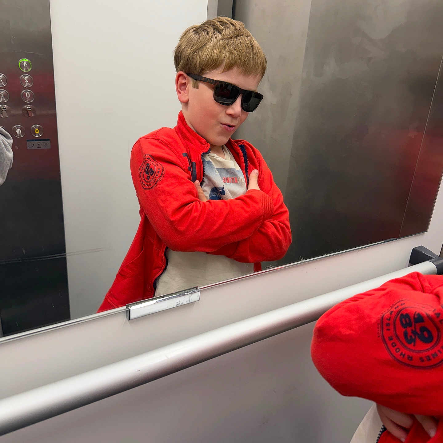 Ioane a rejoint le concours — aidez-le/la à gagner de superbes lots ! child, boy, sunglasses, red_jacket, mirror, reflection, elevator, pose, confident, casual_clothing, short_hair, indoor, young, standing, modern, smile, fashion, cool, hands_crossed, playful