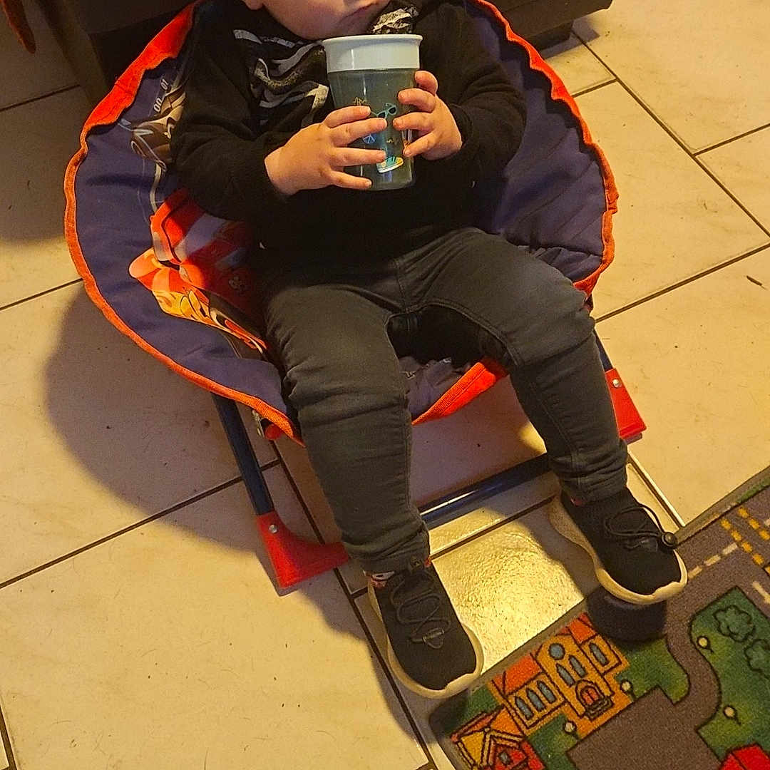 Waïatt participe au concours pour gagner de l'argent avec cette photo : boy, child, clothing, coat, electronics, face, footwear, furniture, head, jacket, jeans, male, mobilephone, pants, person, phone, photography, portrait, shoe, sitting