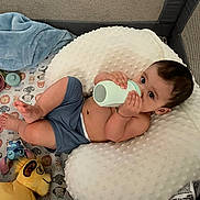 Oatlyn is registered to the contest to win money with this photo: baby, blanket, blue_toy, bottle, child, curious, cushion, face, foot, hand, indoor, infant, lion_toy, pillow, playpen, relaxed, sitting, sleepwear, stuffed_animal, toy