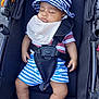 baby, sleeping, stroller, hat, bib, pacifier, child, striped_clothing, outdoor, safety_harness, footwear, relaxation, infant, cute, summer, rest, comfort, person, young_child, peaceful