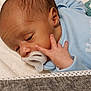 baby, newborn, pacifier, sleeping, infant, blue_clothing, hand, face, skin, blanket, closeup, lying_down, peaceful, tiny_fingers, soft_texture, indoors, portrait, head, resting, cute