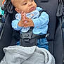 baby, child, stroller, blanket, blue_shirt, bib, mickey_mouse, hands, clasped_hands, face, head, seatbelt, black_stroller, denim, jeans, outdoor, pavement, expression, portrait, infant