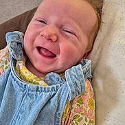 Lysie a rejoint le concours — aidez-le/la à gagner de superbes lots ! baby, smiling, face, denim, overalls, floral, clothing, bed, pillow, happy, infant, cute, child, person, skin, head, lying_down, indoors, young, joyful
