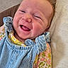 baby, smiling, face, denim, overalls, floral, clothing, bed, pillow, happy, infant, cute, child, person, skin, head, lying_down, indoors, young, joyful