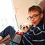 Tchoupi participe au concours pour gagner de l'argent avec cette photo : boy, glasses, dog, couch, handheld_console, gaming, indoor, window, striped_sweater, casual_clothing, relaxed, pet, small_dog, light, young, child, technology, playing, brown_hair, furniture