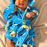 Tatum is registered to the contest to win money with this photo: baby, infant, blue_robe, panda_print, blanket, soft_texture, cute, cozy, face, bare_feet, indoors, portrait, child, smiling, fuzzy_clothing, lying_down, warm, comfort, small_hands, adorable
