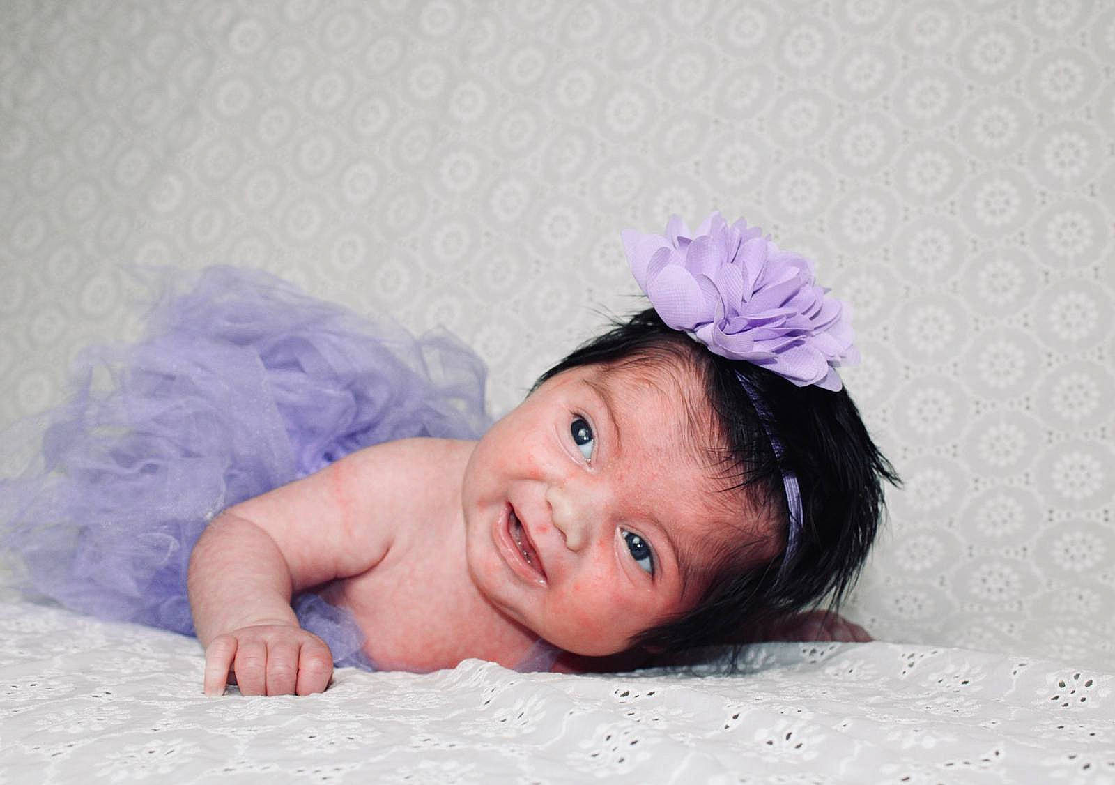 Héléna a rejoint le concours — aidez-le/la à gagner de superbes lots ! baby, baby_toddler_clothing, child, eyebrow, hair_accessory, happy, head, headband, headgear, headpiece, linens, magenta, person, petal, pink, purple, skin, smile, textile, toddler