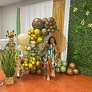 Zhyonnia joined the competition — help win amazing prizes! balloons, basket, casual_footwear, celebration, child, decorations, event, festive, floor_tiles, girl, glasses, gold_curtain, grass, greenery, indoor, plush_giraffe, posing, smiling, striped_dress, wicker_chair