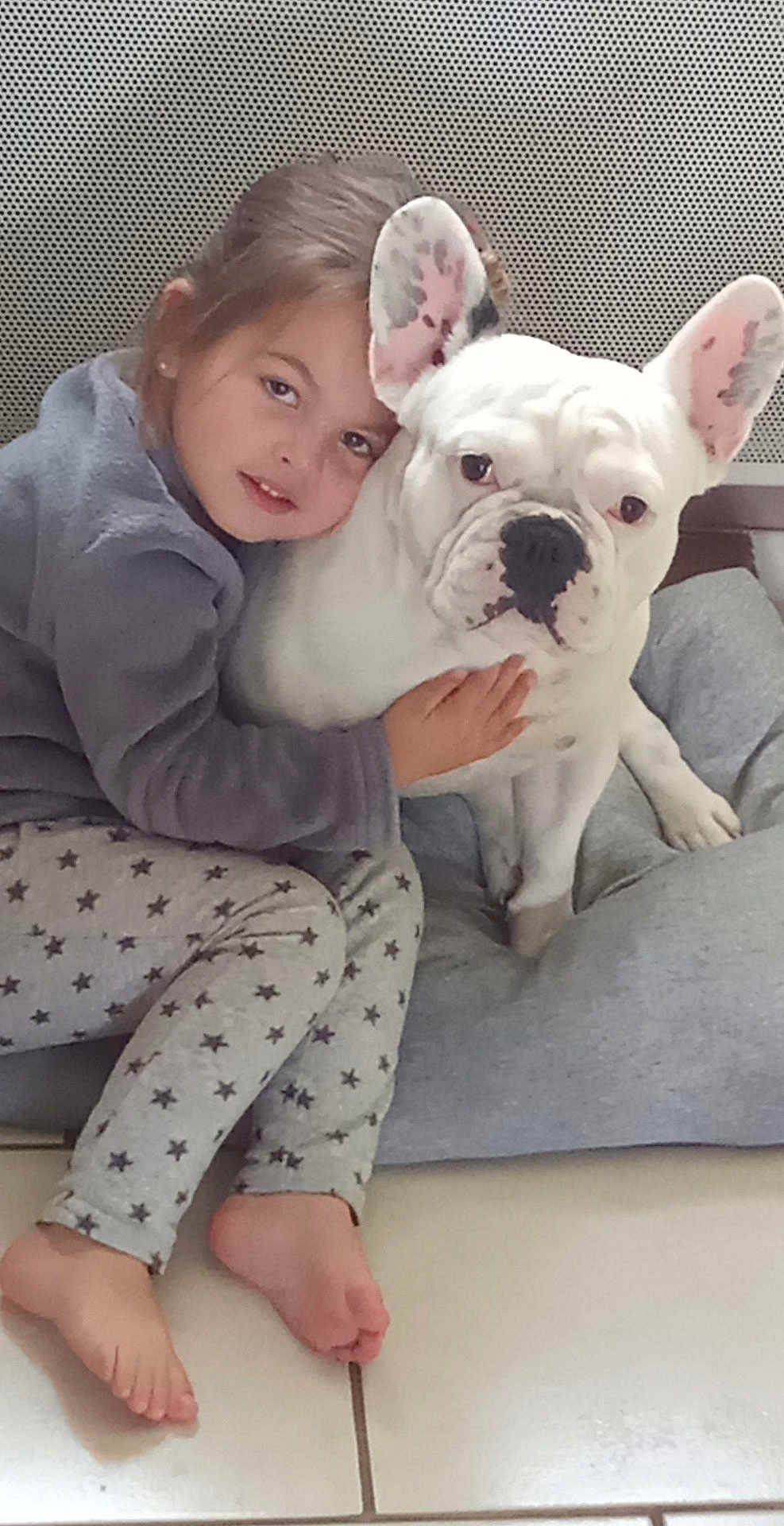 Ruben a rejoint le concours — aidez-le/la à gagner de superbes lots ! child, dog, french_bulldog, hug, cuddle, pajamas, stars, indoor, cushion, pet, barefoot, floor, comfort, affection, face, expression, closeup, young, friendship, resting