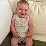 baby, child, smiling, sitting, couch, beige, striped_shirt, khaki_shorts, happy, face, skin, indoors, casual_clothing, infant, cute, portrait, young_child, furniture, relaxed, comfort