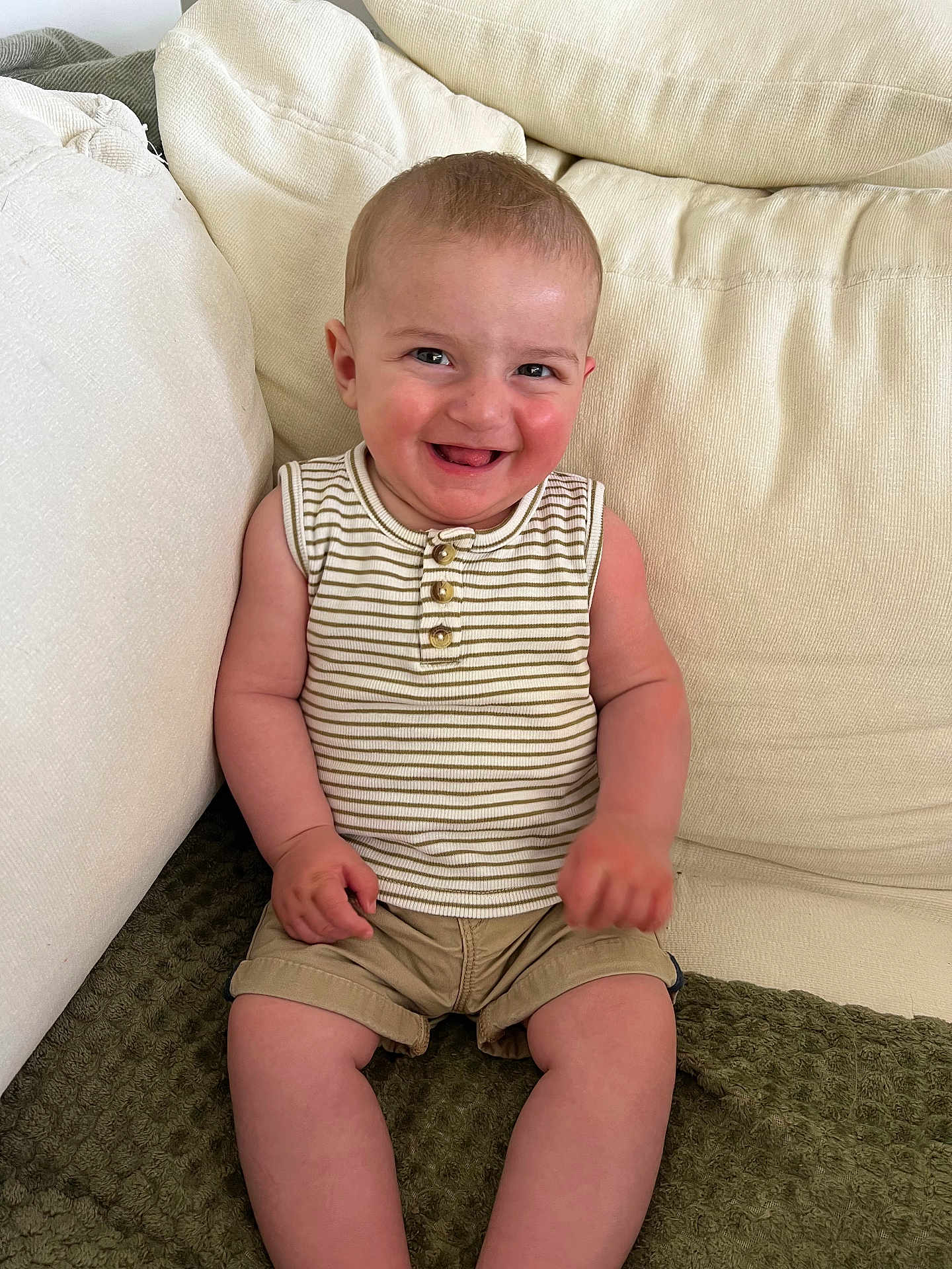 Gaspard participe au concours pour gagner de l'argent avec cette photo : baby, child, smiling, sitting, couch, beige, striped_shirt, khaki_shorts, happy, face, skin, indoors, casual_clothing, infant, cute, portrait, young_child, furniture, relaxed, comfort