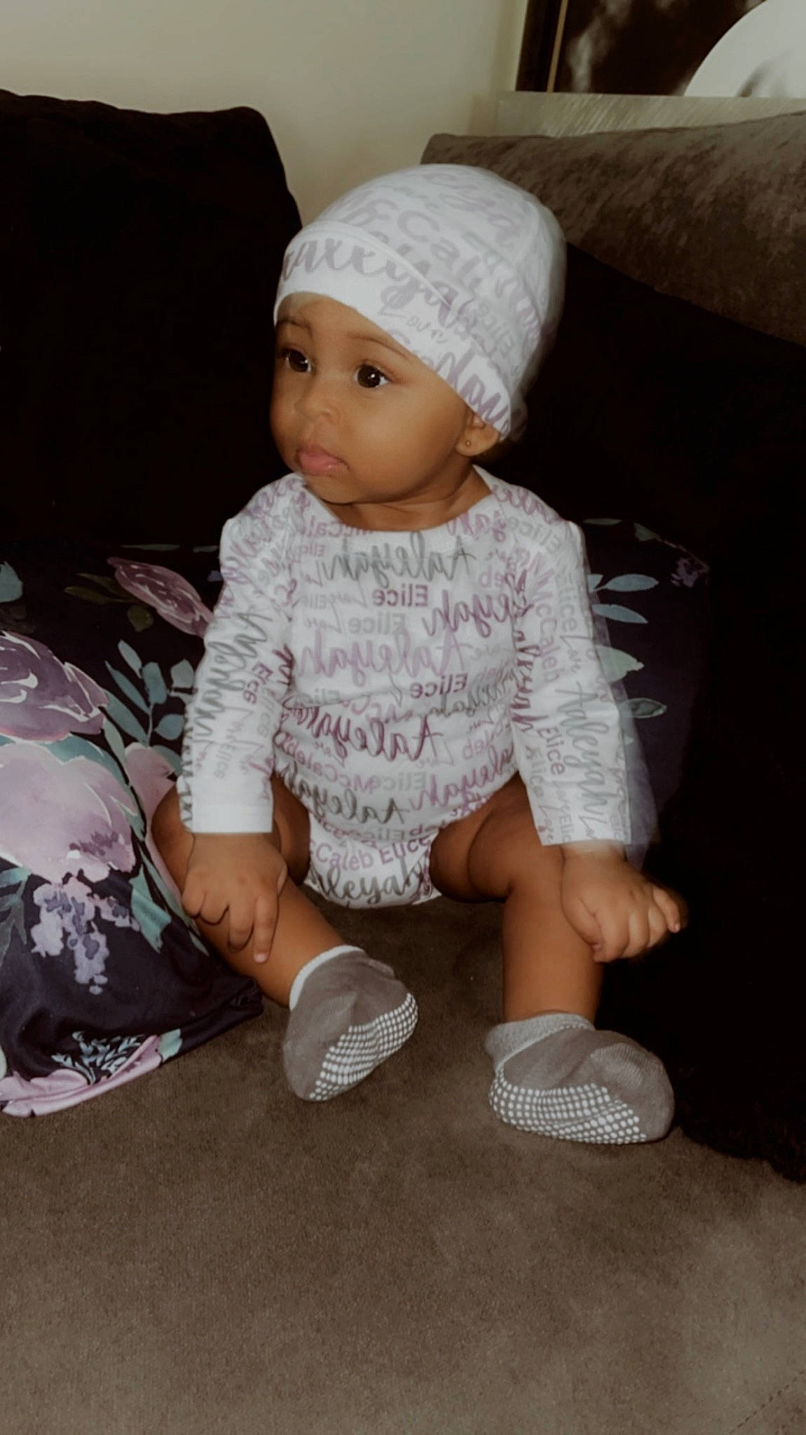 Aaleyah joined the competition — help win amazing prizes! baby, baby_toddler_clothing, beanie, cap, child, comfort, cool, face, fashion_accessory, headwear, knit_cap, linens, pattern, person, room, sitting, sleeve, sock, textile, toddler