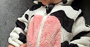 Dominic joined the competition — help win amazing prizes! baby, child, infant, smile, face, hand, clothing, onesie, cow_pattern, pink_patch, blanket, soft_texture, cute, happy, portrait, lying_down, toddler, human, skin, head
