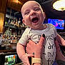 Theo joined the competition — help win amazing prizes! baby, bar, bottle, child, clothing, face, food, glass, hand, happy, indoor, infant, laughing, onesie, person, restaurant, smile, table, tattoo, watch