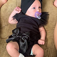 Willow Melson joined the competition — help win amazing prizes! baby, black_outfit, bow, child, cloth, couch, cute, feet, flower_socks, headwear, indoor, infant, legs, pacifier, pacifier_clip, person, relaxing, socks, soft_fabric, toddler