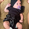 baby, black_outfit, bow, child, cloth, couch, cute, feet, flower_socks, headwear, indoor, infant, legs, pacifier, pacifier_clip, person, relaxing, socks, soft_fabric, toddler
