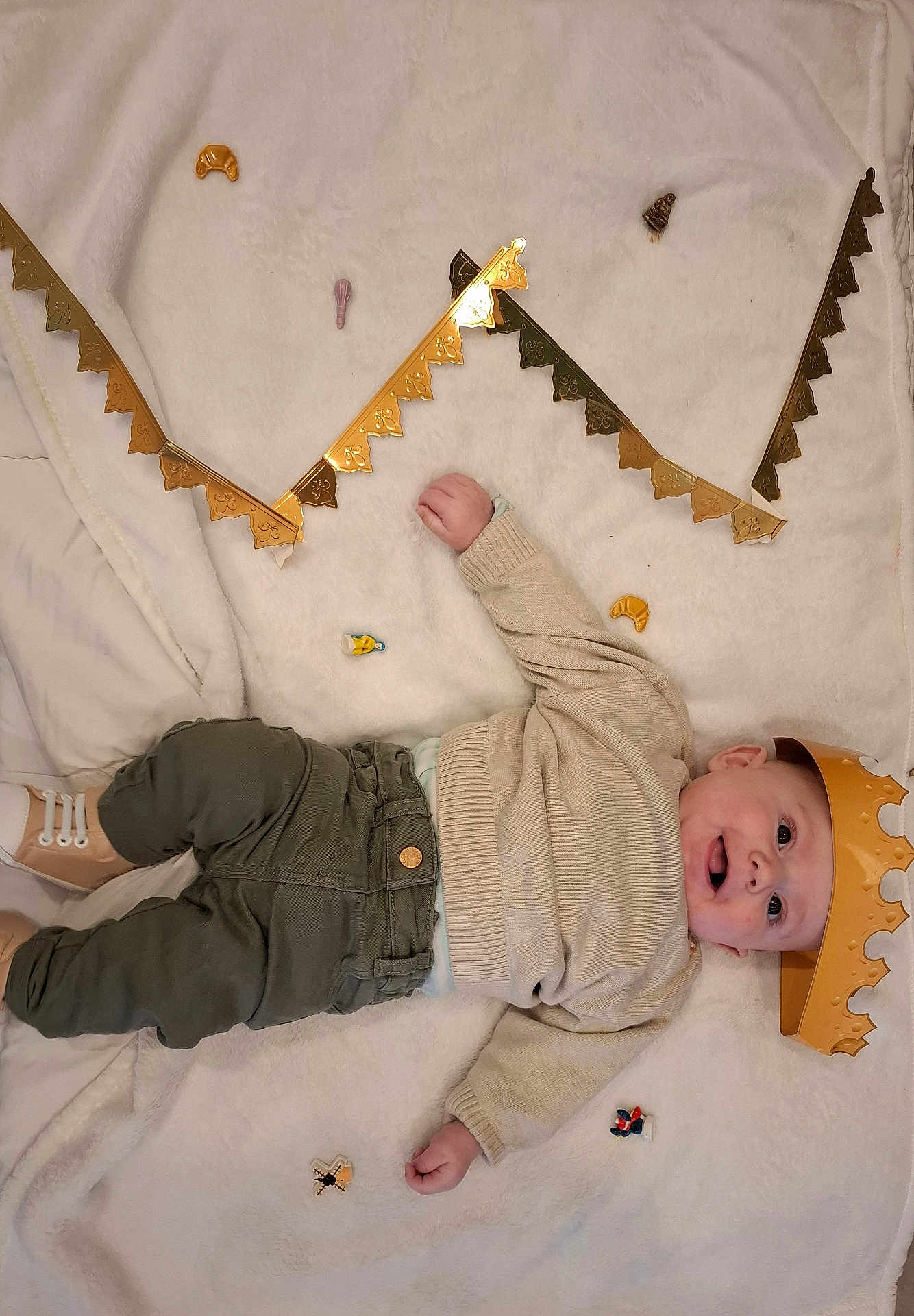 Tyler a rejoint le concours — aidez-le/la à gagner de superbes lots ! baby, crown, blanket, toy, gold_decoration, child, smile, laying_down, clothing, sweater, pants, shoes, indoor, cute, happy, infant, celebration, soft_texture, small_objects, portrait