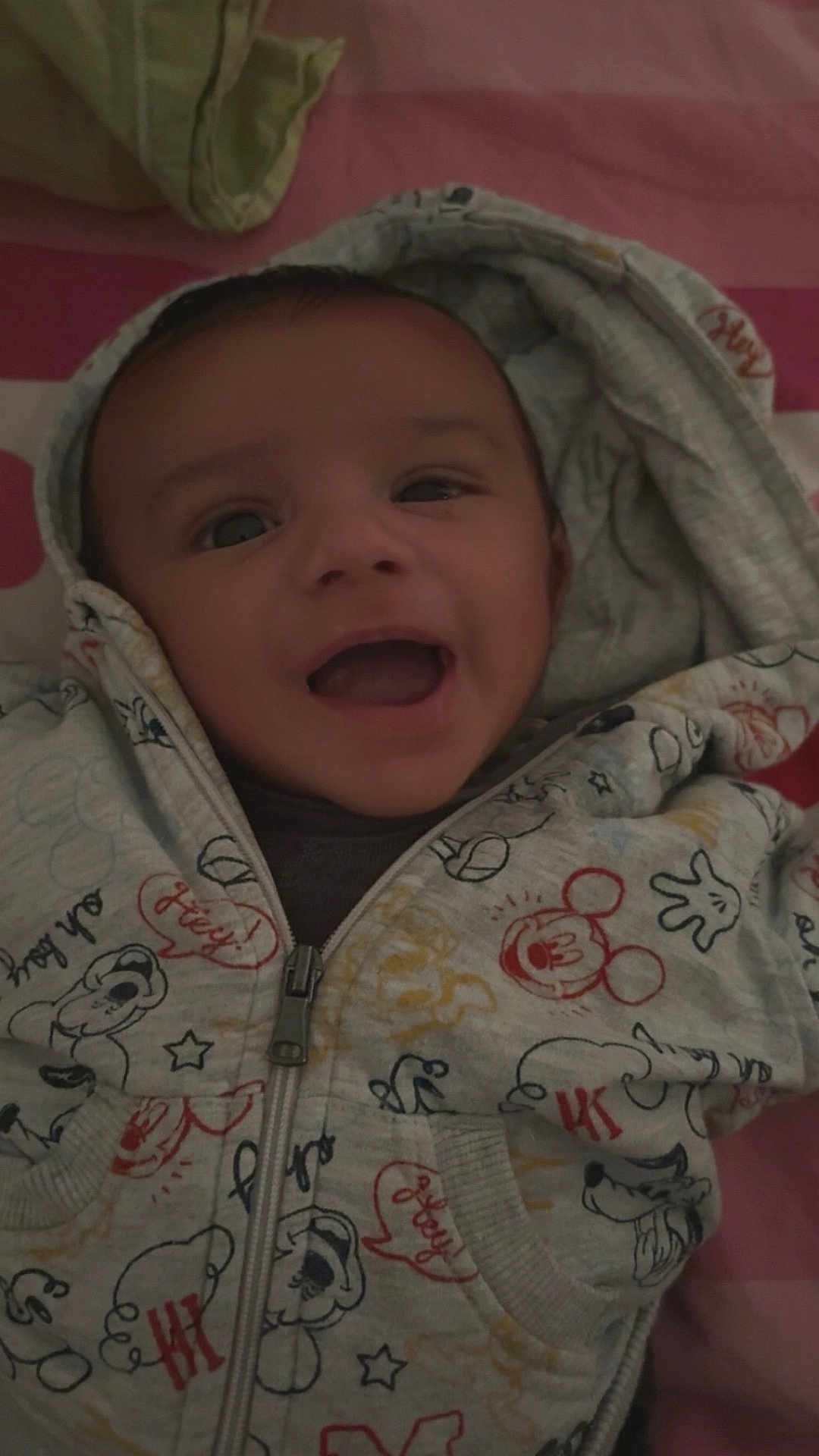 Yanis a rejoint le concours — aidez-le/la à gagner de superbes lots ! baby, hoodie, smile, face, infant, child, clothing, bed, blanket, cute, happy, portrait, young_child, apparel, zipper, fabric, indoor, cartoon_print, person, cozy