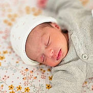 Aria participe au concours pour gagner de l'argent avec cette photo : baby, newborn, sleeping, hat, knitwear, blanket, floral_pattern, peaceful, infant, cute, soft, portrait, child, resting, closeup, cozy, indoors, skin, hand, face