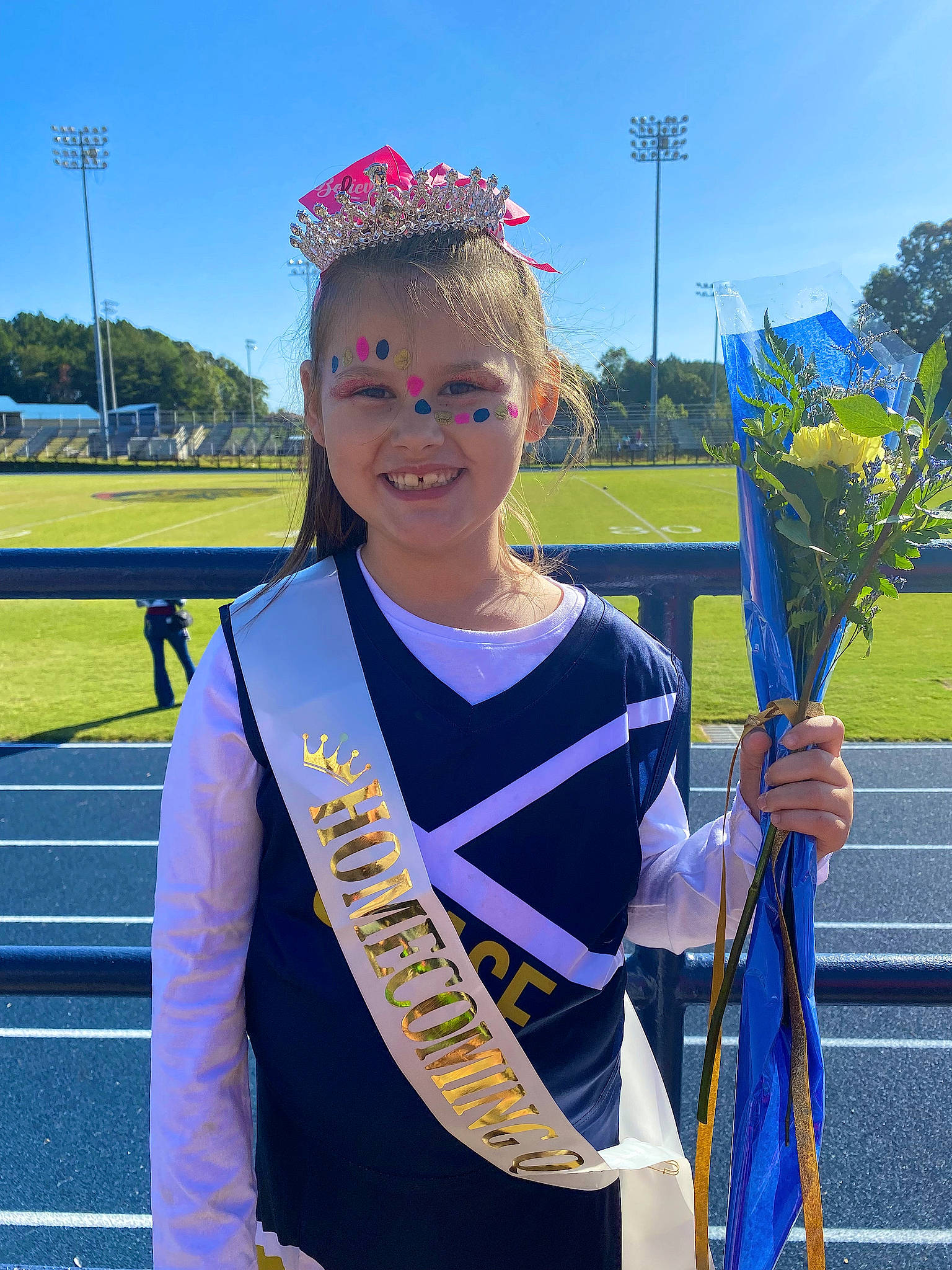 Reagan joined the competition — help win amazing prizes! cheerleading_uniform, electric_blue, event, flowering_plant, fun, grass, happy, jewellery, joy, person, plant, plant_stem, pole, recreation, sky, smile, sportswear, tree, uniform