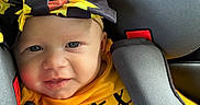 Ava is registered to the contest to win money with this photo: baby, blue_eyes, car_seat, child, closeup, cute, face, happy, headband, indoor, infant, person, portrait, safety, seatbelt, smile, straps, sunflower_pattern, yellow_clothing, young_child