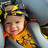 Ava is registered to the contest to win money with this photo: baby, child, car_seat, headband, yellow_clothing, smile, blue_eyes, face, seatbelt, infant, cute, sunflower_pattern, happy, closeup, indoor, person, young_child, safety, straps, portrait