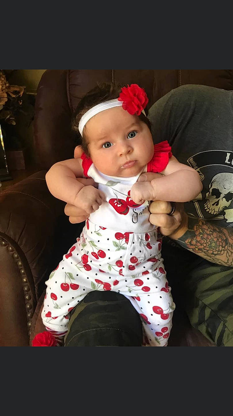 Aniston is registered to the contest to win money with this photo: baby, cheek, child, headwear, person, sitting, toddler