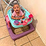 Justice is registered to the contest to win money with this photo: baby, baby_toy, child, clothing, colorful, face, floor, hands, happy, head, indoor, person, pink_shirt, seat, shadow, smile, tile, toy, walker, wall