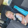 child, toddler, car_seat, seatbelt, blonde_hair, car_interior, window, vehicle, serious, young_child, seat, safety, travel, road_trip, blue, clothing, person, young, resting, indoors