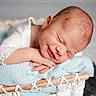 Waylon is registered to the contest to win money with this photo: newborn, baby, sleeping, smiling, basket, blanket, white_clothing, soft_texture, infant, cute, peaceful, resting, portrait, close_up, head, hands, indoor, baby_pose, knitwear, cozy
