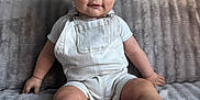 Ezio a rejoint le concours — aidez-le/la à gagner de superbes lots ! baby, infant, child, couch, sofa, overalls, white_clothing, socks, indoor, soft_texture, cute, portrait, seated, smiling, person, home, furniture, looking_at_camera, short_hair, happy